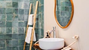 A bathroom with a white sink, a wooden ladder, and a mirror on the wall. - Bucio Coliving (Arona)