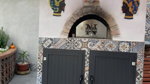 An outdoor brick oven with decorative headpieces, a tiled entrance, and a security camera. - Villa Nicolai with Private Pool for up to 20 Guests (Licata)