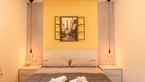 A bedroom with a bed, two bedside tables, a wall-mounted picture, and two pendant lights. - Villa Nicolai with Private Pool for up to 20 Guests (Licata)