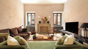 Una sala de estar con chimenea, dos sofás, una mesa de centro y un televisor.