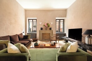 Ein Wohnzimmer mit Kamin, zwei Sofas, einem Couchtisch und einem Fernseher.