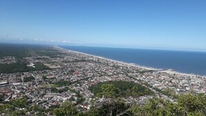 Un paisaje urbano costero con densa construcción, una playa y un cielo azul despejado.
