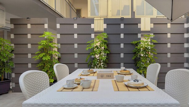 Een eetgedeelte met een tafel voor vier personen, omringd door rieten stoelen.