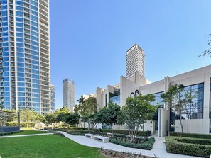 Ein moderner Gebäudekomplex mit einer gewölbten Fassade, einem Dachgarten und einer gepflegten Rasenfläche.