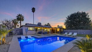 A modern house with a swimming pool, outdoor seating, and a patio area. - Scottsdale Oasis | Pool, Firepit, Putting Green (Scottsdale)