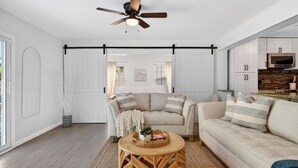 Un salon moderne avec un canapé, une table basse et un ventilateur de plafond.