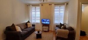 A living room with two sofas, a television, and a small table. - Modern 3BDR Home Heart of The Liberties (Dublin)