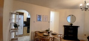 A dining area with a round table, chairs, a chandelier, and a fireplace. - Modern 3BDR Home Heart of The Liberties (Dublin)