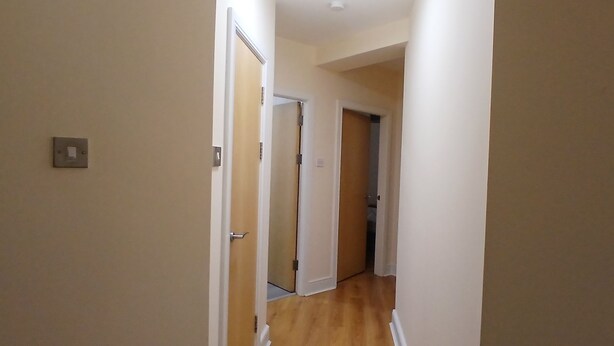 A narrow hallway with wooden flooring and white walls. - Modern 3BDR Home Heart of The Liberties (Dublin)