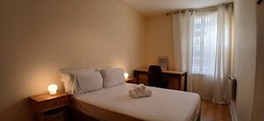A bedroom with a bed, bedside tables, a desk, and a window with curtains. - Modern 3BDR Home Heart of The Liberties (Dublin)