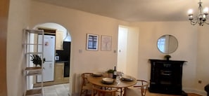 A dining area with a round table, chairs, a chandelier, and a fireplace. - Modern 3BDR Home Heart of The Liberties (Dublin)