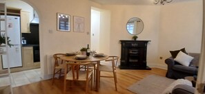 A dining area with a table set for four, a fireplace, and a sofa in a living room. - Modern 3BDR Home Heart of The Liberties (Dublin)