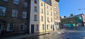 A street view with multi-story buildings, a speed limit sign, and a mural on a building. - Modern 3BDR Home Heart of The Liberties (Dublin)