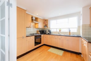 Una cucina moderna con mobili in legno, un piano cottura e una finestra che lascia entrare luce naturale.