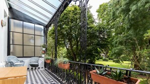 A checkered floor, outdoor seating, potted plants, and a garden view. - Beautiful 2bed Flat With Balcony in Earls Court (London)