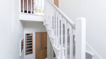 A staircase with white railings and a wooden door at the bottom.