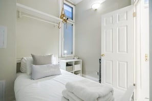 A bedroom with a bed, a bedside table, a window, and a door. - Beautiful Refurbished 2bed 2bath Next to Hyde Park (London)