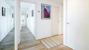 A hallway with white walls, wooden flooring, and a framed cityscape picture on the wall. - Spacious 2bed in top Location Holland Park-n Hill (London)