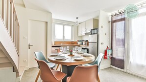 A modern kitchen with a dining area. - La Maison du Soleil Sion sur l'océan (Saint-Hilaire-de-Riez)