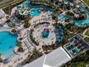 Vista aérea de un complejo turístico con varias piscinas, toboganes de agua y tumbonas.