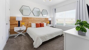 Una camera da letto moderna con una testiera in legno, un letto grande e tre specchi esagonali.