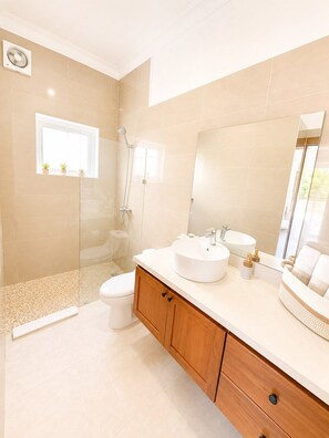 Ein modernes Badezimmer mit Toilette, Waschbecken und Dusche.