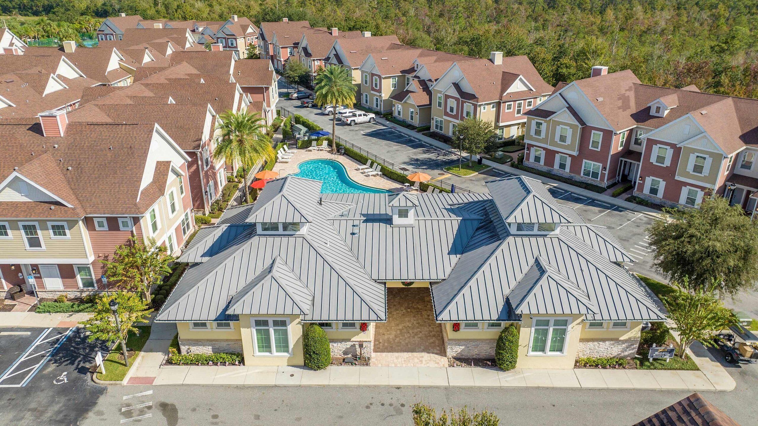 A residential area with multiple houses, a swimming pool, and a parking lot.