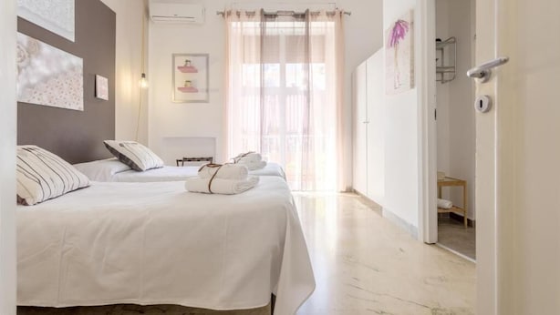 Hotellihuone, jossa on kaksi sänkyä, kylpyhuone ja näkymä ulos.