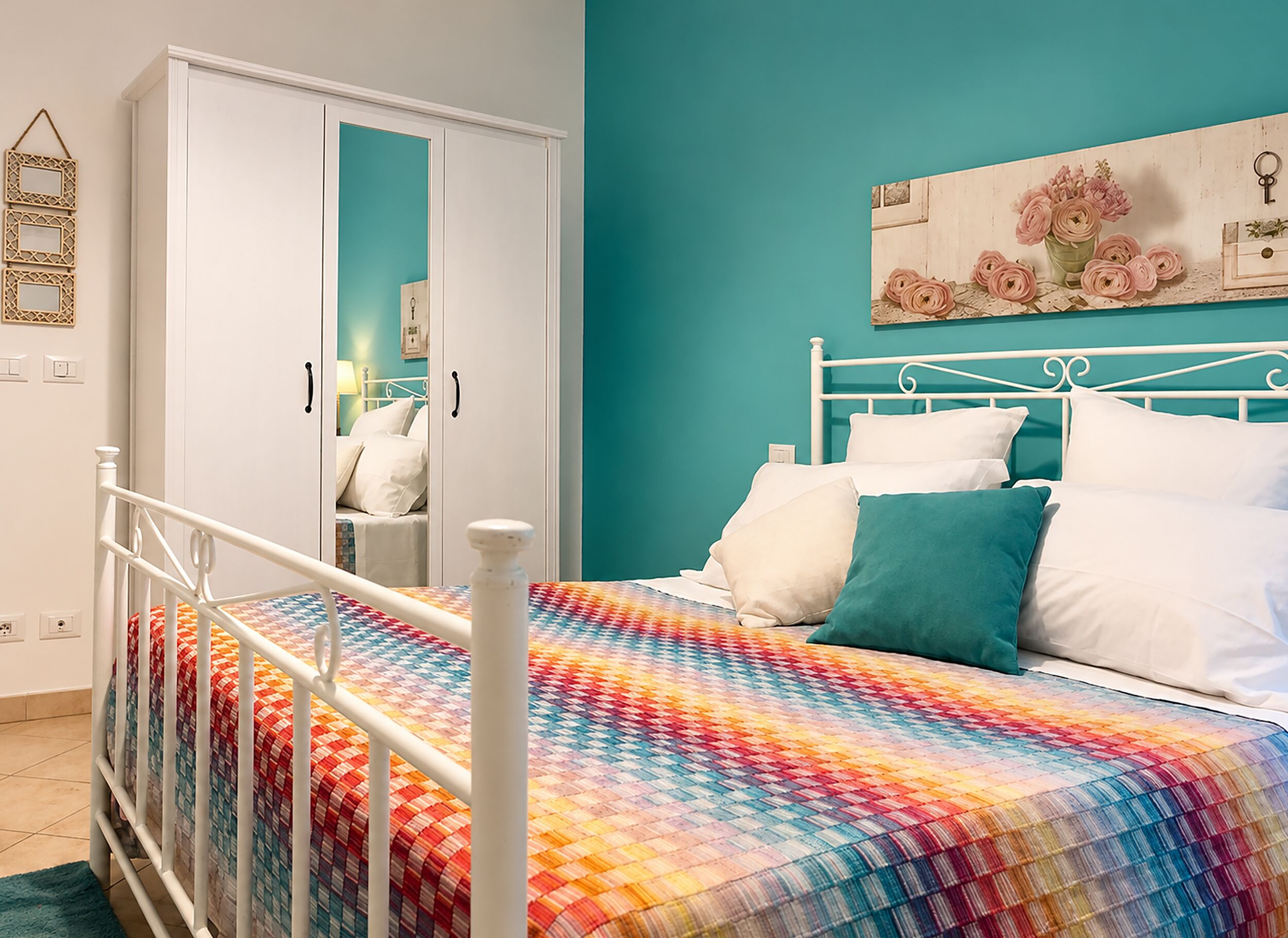 A bedroom with a bed, a wardrobe, and a mirror.