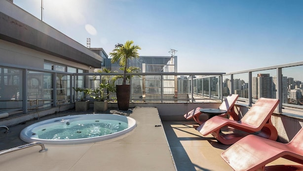 A rooftop terrace with a hot tub, lounge chairs, and a view of the city skyline. - Stay Steps fr/ the Metro and Ibirapuera Mall in Indianopolis - Noes (São Paulo)