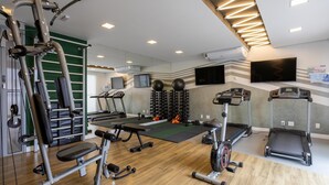 A modern gym with treadmills, weight machines, and a wall-mounted exercise ball rack. - Stay Steps fr/ the Metro and Ibirapuera Mall in Indianopolis - Noes (São Paulo)