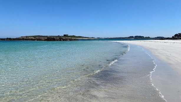 A beach with clear turquoise water, a sandy shore, and rocky outcrops in the distance. - Comfortable apartment with an incredible sea view (Landéda)