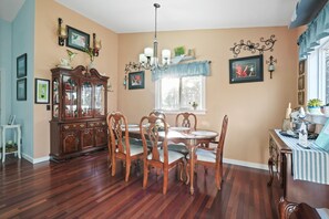A dining room with a wooden table and chairs, a china cabinet, and a chandelier. - Vista Retreat | Hocking Hills, Hot Tub, Pets (Rockbridge)