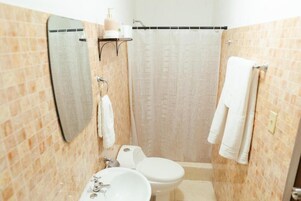 Un baño con inodoro, lavabo y espejo.