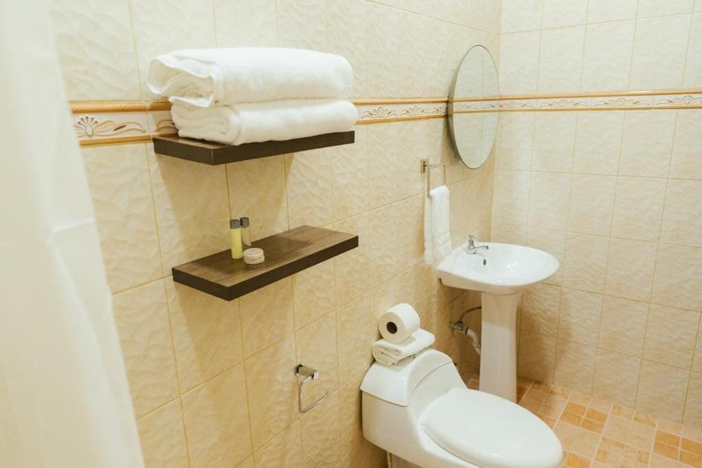 Un baño con inodoro, lavabo y barra para toallas.