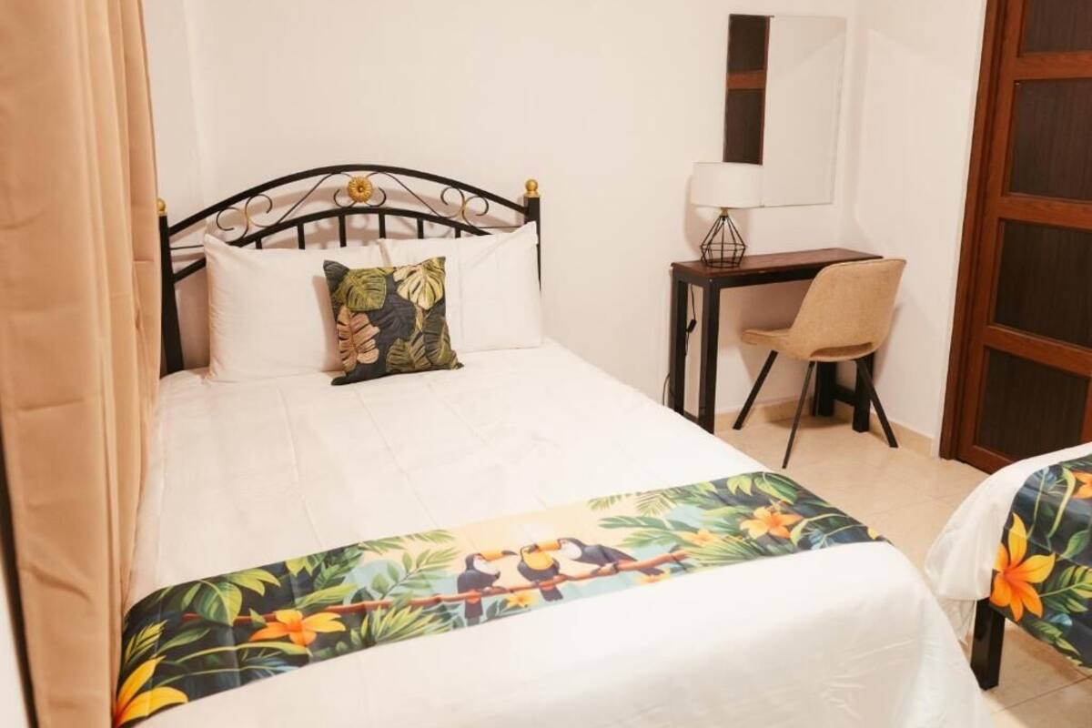 Une chambre d’hôtel avec un lit, un bureau et une chaise.