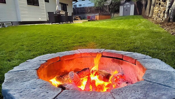 En pejsesten med flammer i en baghave.