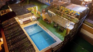 Un hôtel à plusieurs étages doté d’une piscine, d’un espace extérieur aménagé et offrant une vue sur les environs.