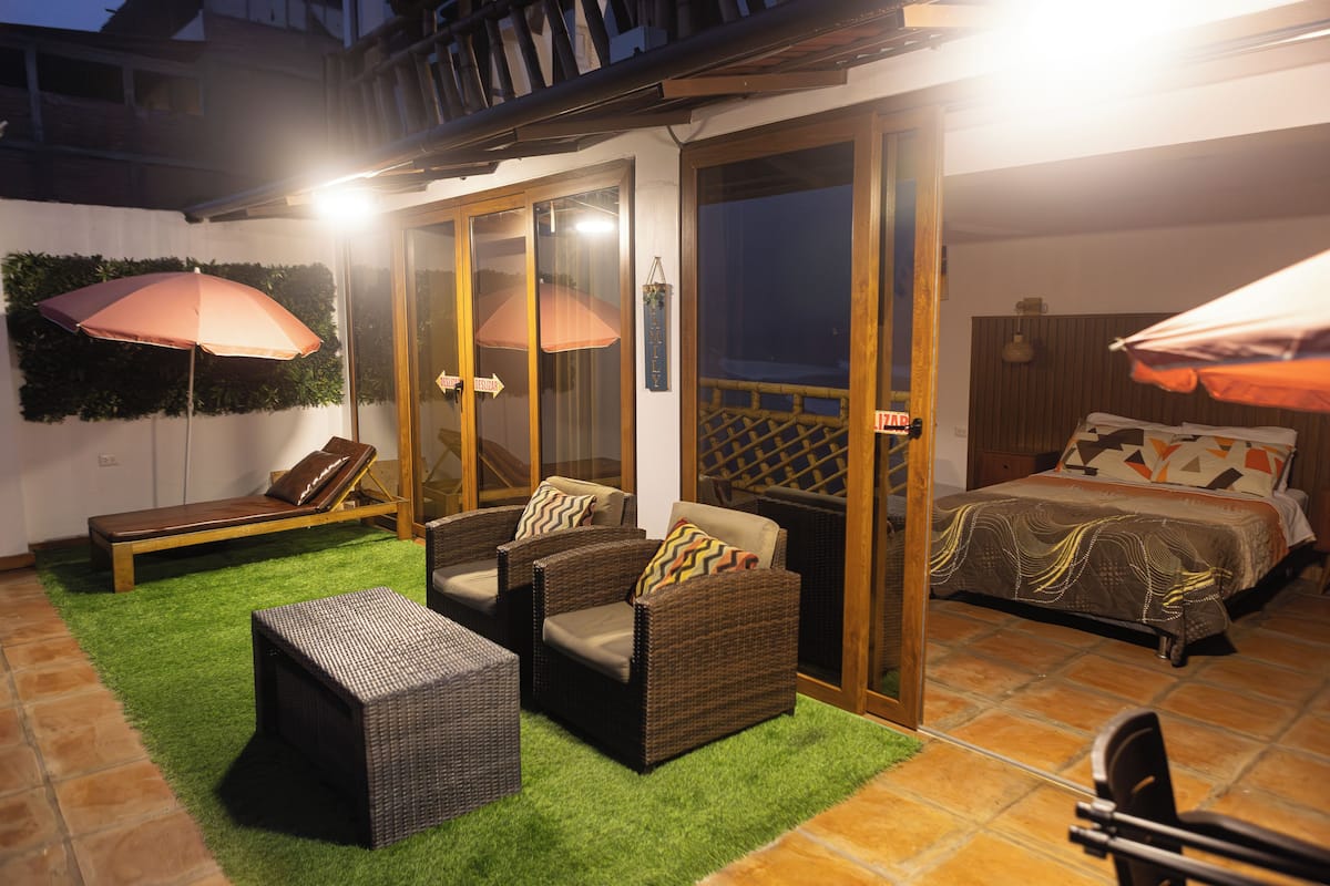 A bedroom with a bed, a sofa, and two chairs.