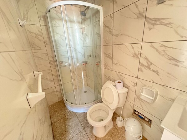 A bathroom with a shower enclosure, a toilet, and a bidet. - Hotel Sunset Chancay (Chancay)