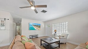 Una sala de estar con sofá, mesa de centro y televisor.