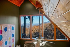 Ein Zimmer mit großem Fenster und Blick auf eine Berglandschaft.