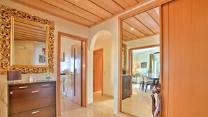 A hallway with a wooden ceiling, a large ornate mirror, a wooden cabinet, and a wooden sculpture. - Excellent Private Penthouse with lots of space (Lagos)