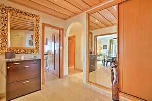A hallway with a wooden ceiling, a large ornate mirror, a wooden cabinet, and a wooden sculpture. - Excellent Private Penthouse with lots of space (Lagos)