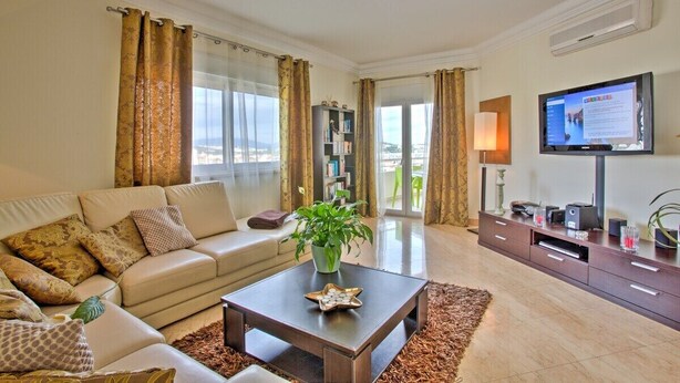 A living room with a sofa, coffee table, TV, and a bookshelf. - Excellent Private Penthouse with lots of space (Lagos)