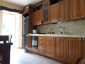 Una cocina con armarios de madera, un lavamanos de acero inoxidable y un horno empotrado.