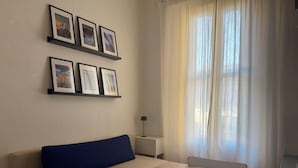 A room with a sofa, a table, and a window with curtains. - B91 by VIDI · Bright Milanese flat near Navigli, direct tram to Duomo (Milano)