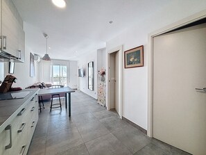 Eine moderne Küche mit Essbereich, großen Fenstern und Blick ins Freie.
