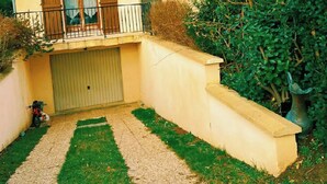 A two-story house with a red-tiled roof, a covered driveway, and a small balcony. - Charming house 40 min from Paris (Bondoufle)