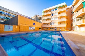 Ein Schwimmbecken, umgeben von mehrstöckigen Gebäuden mit Balkonen.